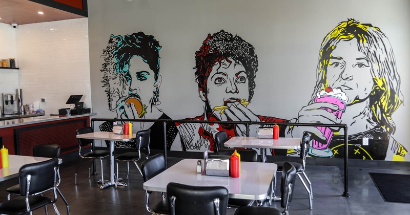 Inside, dining area with mural art on a wall