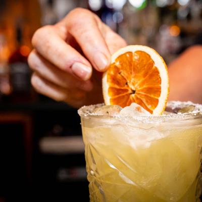 Garnishing a cocktail glass with a citrus wheel, close up