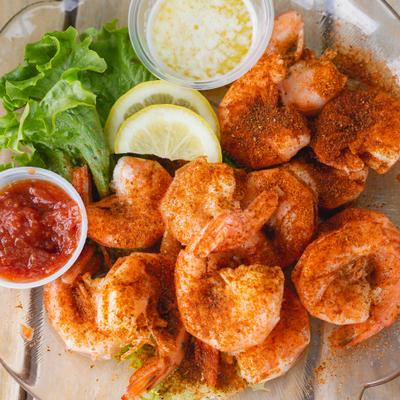 Seasoned gulf shrimp served with cocktail sauce, butter, and lemon slices.