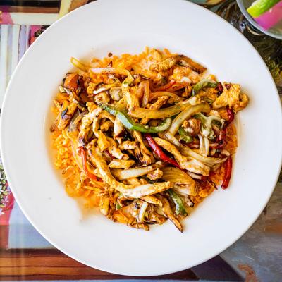 Rice bowl, with grilled chicken, cheese, onions, and bell peppers.