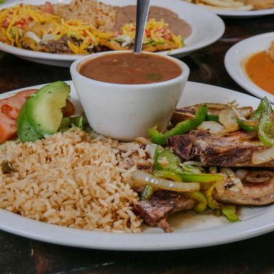 Beef fajitas with rice, beans, and vegetables.