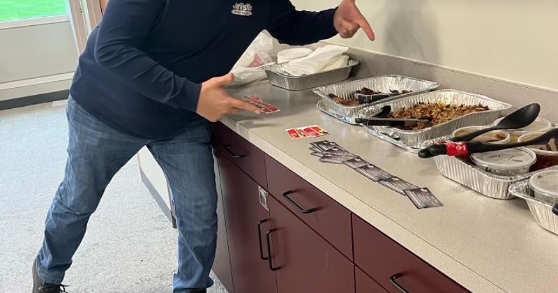 A person pointing at a table with catering food