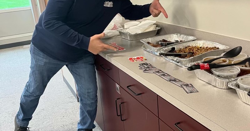 A person pointing at a table with catering food