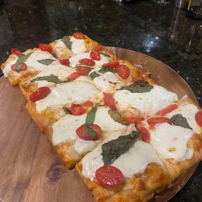 Flatbread topped with cheese, pepperoni and basil.