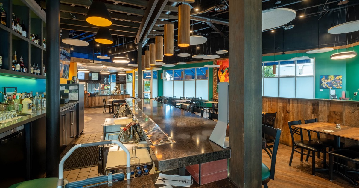 Interior, a view of the bar with tables and chairs in the back