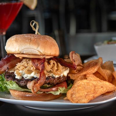 Bacon cheeseburger, with blue cheese, lettuce, tomato, onion, pickles, and chips.