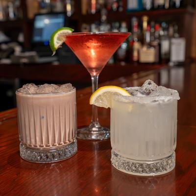 Three different cocktails served on the bar counter.
