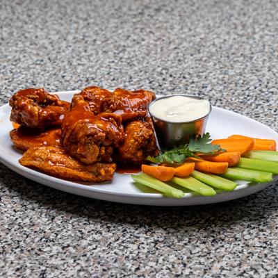 Buffalo wings served with creamy dipping sauce, carrots, and celery sticks.