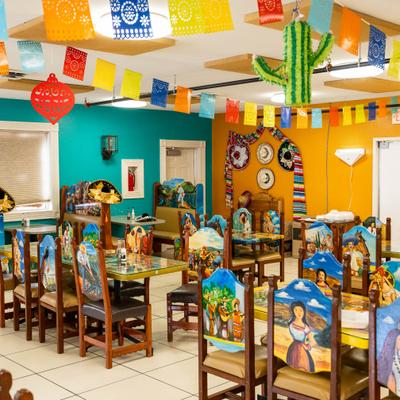 Dining area with painted wooden chairs.