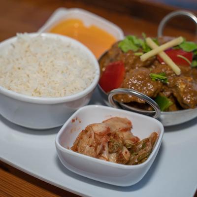 Indian meal with rice, curry, lentil soup, and kimchi.