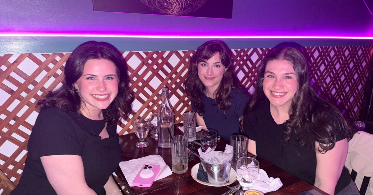 Three people seated together at a restaurant table