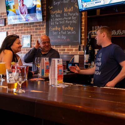 Bartender tending to customers.