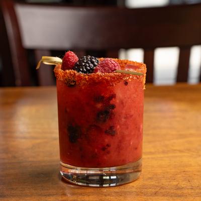 Berry Margarita with a spicy lime rim, garnished with fresh berries on a cocktail pick.
