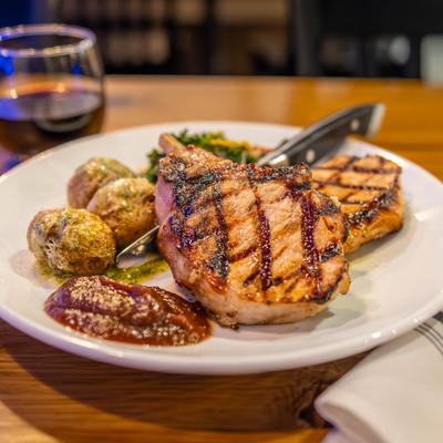 Duroc Pork Chop, Amish apple butter, herb roasted potatoes, coconut cream kale.