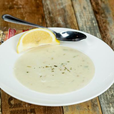Creamy New England-style clam chowder soup with lemon garnish.