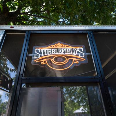 Stubblefield’s BBQ Catering and Events neon sign on a black food truck.