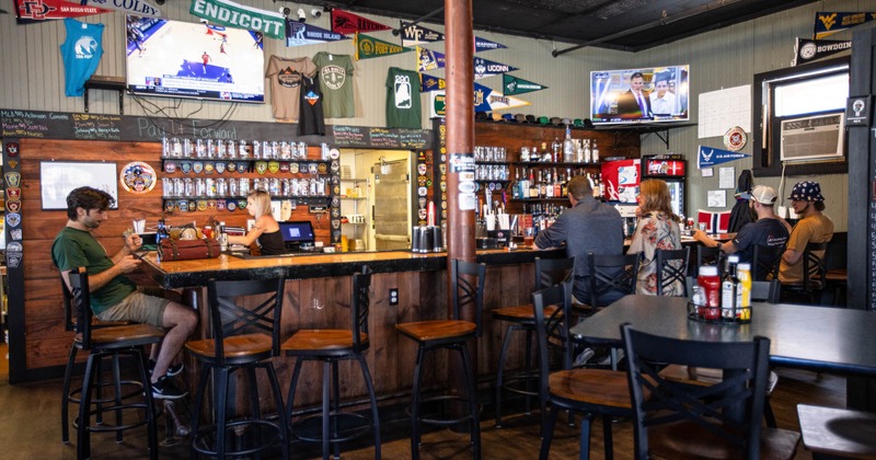 Interior, bar, guests sitting at the bar counter, staff in action