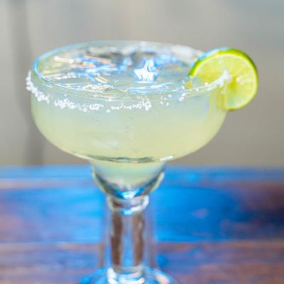 Margarita cocktail with a salted rim and a lime wheel.