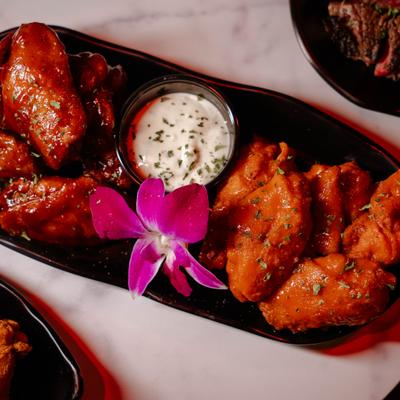 Plate of Chicken Wings served with a dip and garnished with flower.