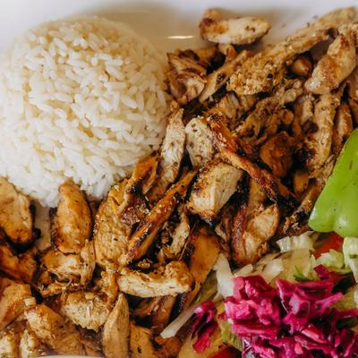 Grilled chicken with rice and pickled cabbage on a plate.