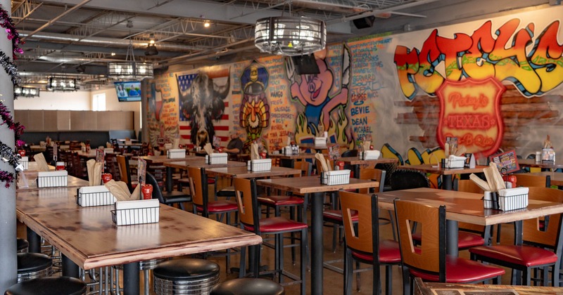 Interior of a casual restaurant with rows of tables, red-and-black seating