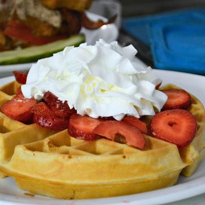 Belgian waffle, with whipped cream and strawberries.
