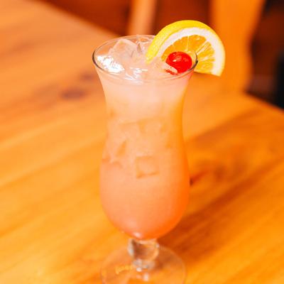 Low country Relaxer cocktail garnished with lemon wedge and cherry.