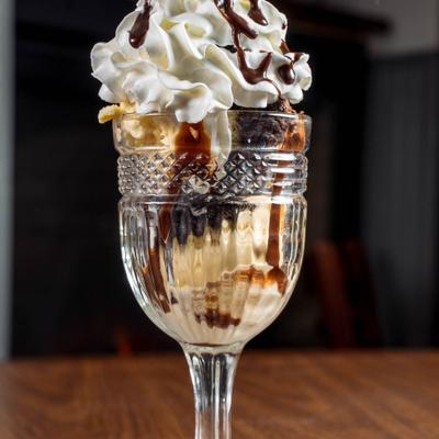 Chocolate fudge brownie sundae with whipped cream and chocolate drizzle.