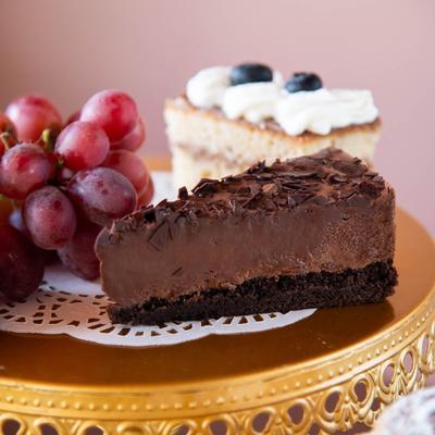 Chocolate Mousse Cake and sponge cake displayed on a golden stand with fresh red grapes.