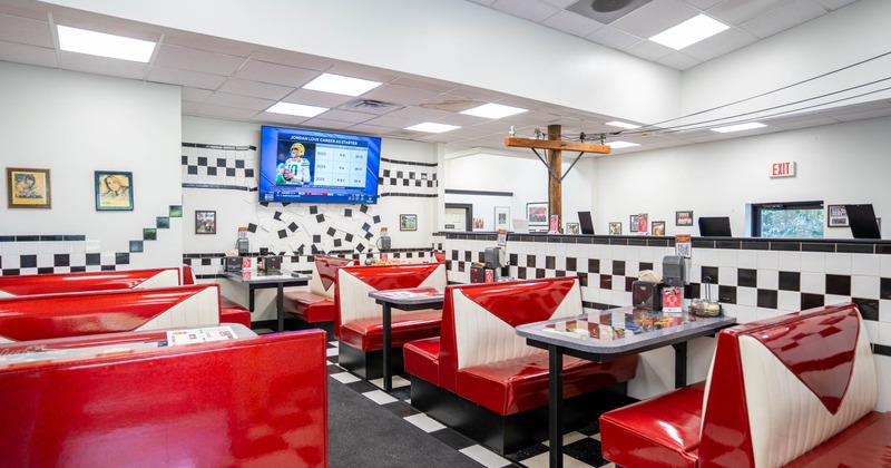 Bright diner interior with red booths and checkered floor