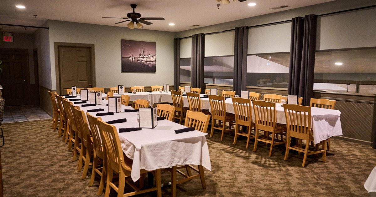 Interior, ''U'' shaped long table setup, ready for guests, carpet flooring, ceiling fans