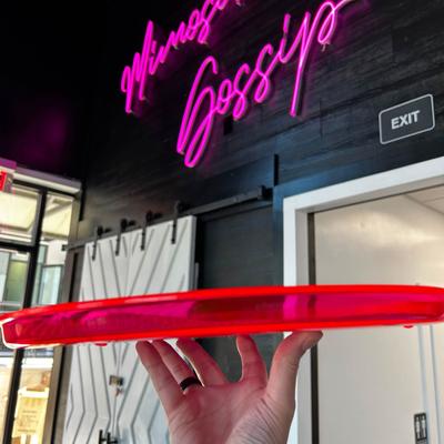 A person holding a tray in front of Mimosa Gossip sing on a wall.