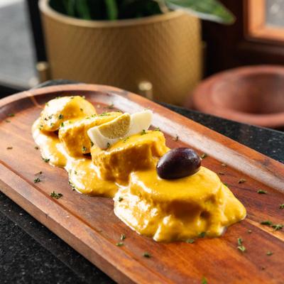 Peruvian potato appetizer with creamy sauce, egg, and olives.