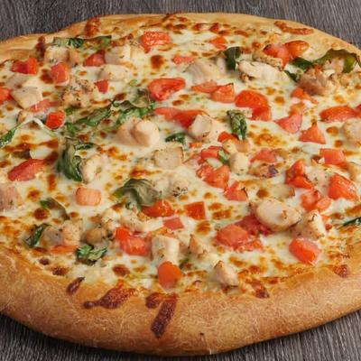Chicken pizza with tomatoes and spinach.