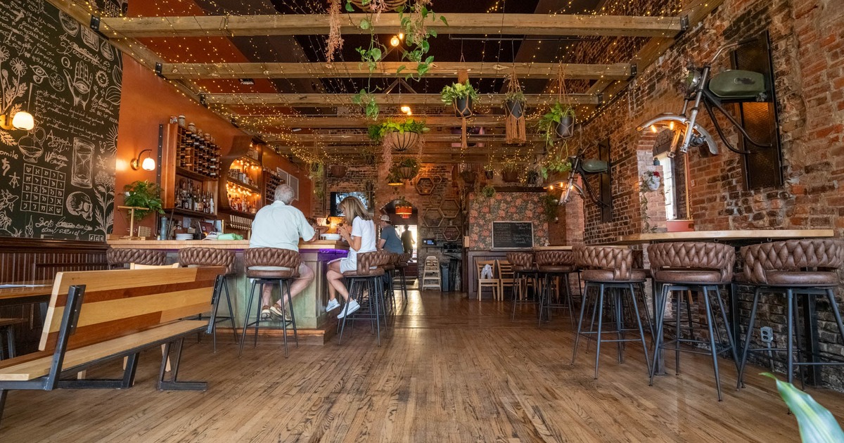 Interior with high-top seating, wooden beams, and hanging plants