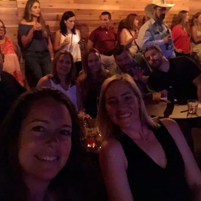 Group of cheery guests take a selfie together inside the bar.