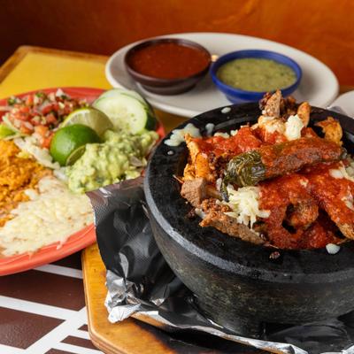 Molcajete served with rice, beans, and guacamole.