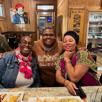 Three people posing at the bar.