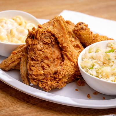 Fried chicken served with coleslaw and mac and cheese.