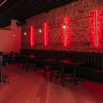 Dining room with red lights and banquette seating.