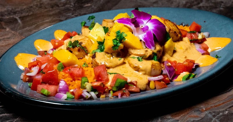 Scallops and rice dish topped with a fresh mango salsa and sauce