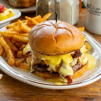 Breakfast Burger with beef and sausage patties, bacon, hollandaise sauce and a side of fries.
