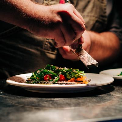 Chef grating truffles over a salad.