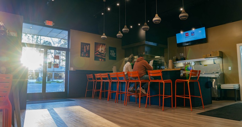 Interior with bright orange stools and a bar