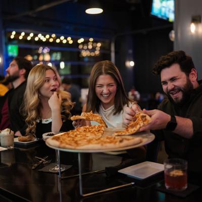 People sharing a pizza at the table.