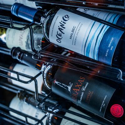 Wine bottles resting in metal rack.