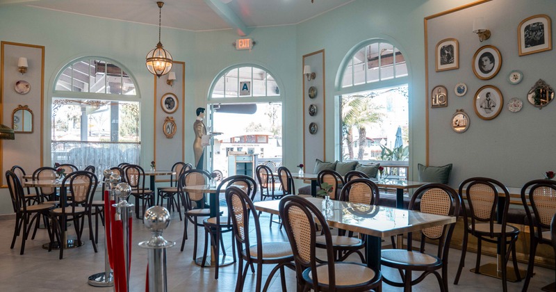 Interior - light blue walls, dark wooden furniture, arched windows and decorative plates.