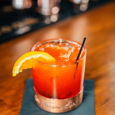 Orange Old Fashioned with an orange wedge.