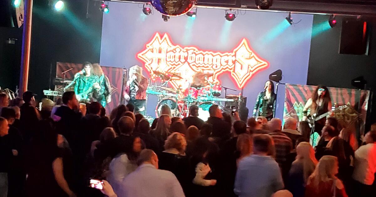 Metal tribute band performing on stage with a crowd watching