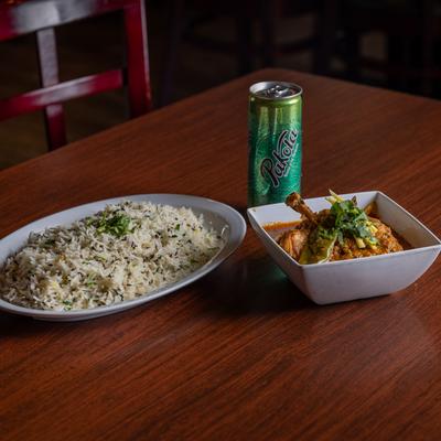 Chicken leg, with tomato based butter cream sauce, serrano peppers, herbs, spices, rice, and soda.